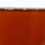 Ready-to-use ZERUST Axxatec 85-F dark amber liquid in a container, forming a clear, dry coating on metals, safe for painted surfaces and plastics.