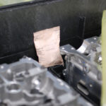Close-up of flash corrosion VCI emitter in dunnage for motor block safety