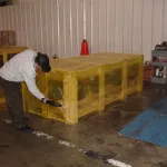 Crate being shrink-wrapped with VCI shrink film using heat gun