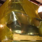 Metal parts on pallet wrapped in VCI shrink film for storage