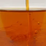ZERUST Axxanol 710C being precisely added to 5w-30 motor oil, illustrating the dilution process for optimal corrosion protection.