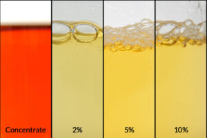 ZERUST Axxatec 30C concentrate alongside its dilutions at 2%, 5%, and 10% levels, demonstrating the product's versatility as a water-based rust inhibitor.