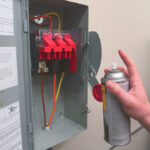 ZERUST Axxanol 718-ESS electrical corrosion inhibitor spray applied on an electrical panel, showcasing its protective, non-staining film against corrosive environments.