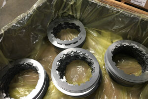 Close-up of clutch plates being packaged in ICT510C-AN, highlighting the nitrite-free and non-amine VCI film's detail.