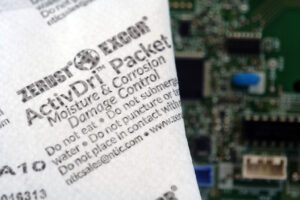 Close-up of moisture control packet with circuit board for enhanced protection