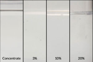 Image of ZERUST Axxatec DA-23C concentrate alongside diluted solutions at 3%, 10%, and 20% for effective rust prevention and cleaning.