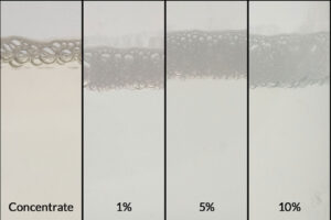 Image of ZERUST AxxaWash KMS-305AL product concentrate alongside its 1%, 5%, and 10% dilutions, designed for efficient aluminum part cleaning.