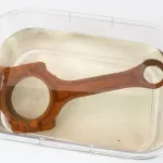 Immersion of a rusty connecting rod in ZERUST AxxaClean ICT625-RR for rust removal.