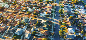 Neighborhood with homes and greenery, symbolizing the reduction in CO₂ emissions equivalent to 47.8 households, achieved by NTIC/ZERUST using renewable energy sources.