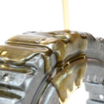 Non-staining rust preventive oil being poured onto a metal part to show its viscosity.