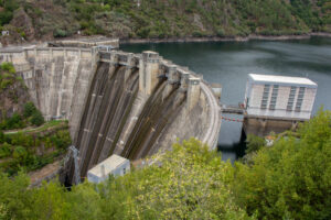 Hydroelectric power plant showing dam, turbines, and water flow.