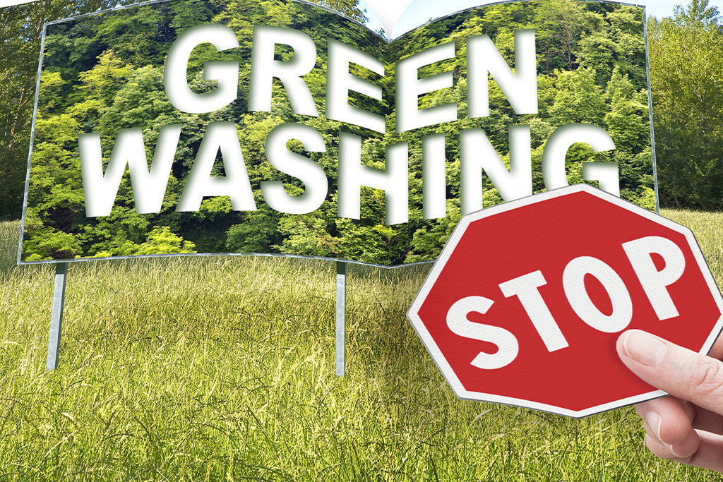Billboard with the phrase “green washing” and a stop sign in front