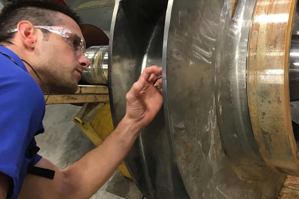 Technician reviewing rusted component for analysis