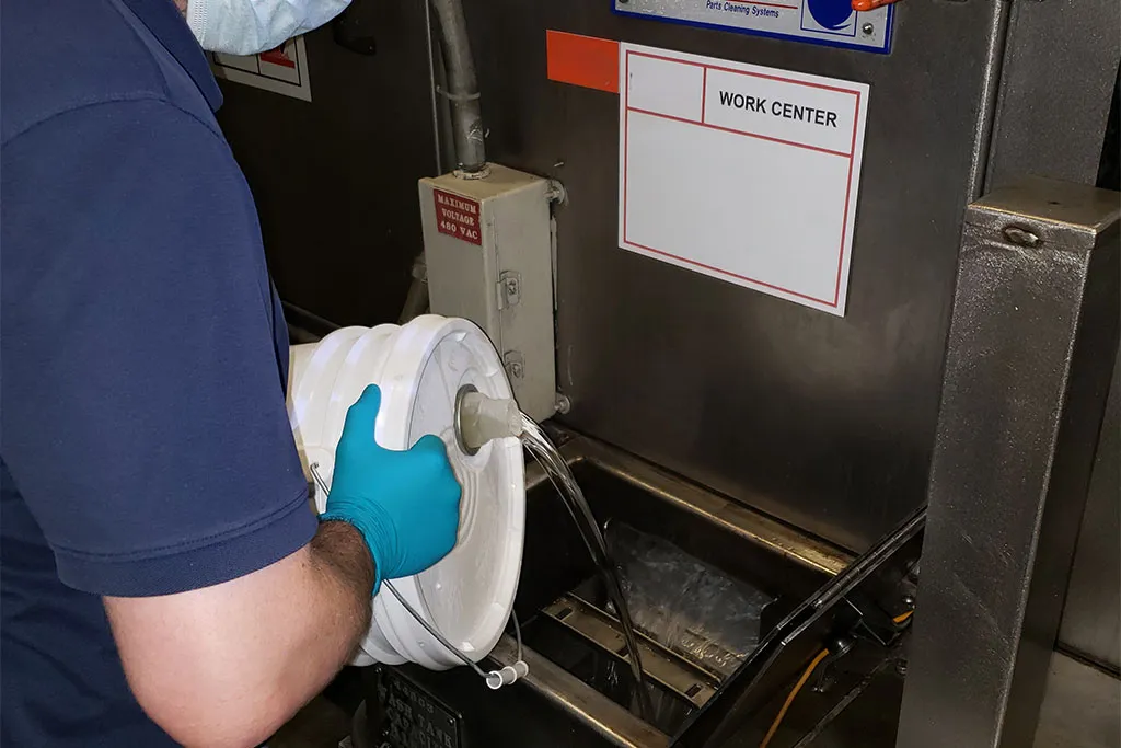 Technician servicing parts cleaner fluid management system