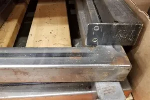 Machinery rusting from direct contact with wooden pallet causing corrosion
